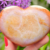 Smooth carnelian heart in the palm of 6.4 cm