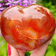 Heart made of carnelian stone in the palm of 6.1 cm